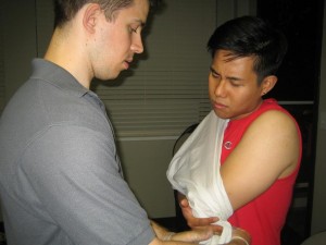 Tying a tube sling to immobilize and injured arm in Grande Prairie First Aid